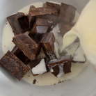 Для трюфеля кусочки шоколада положить в жаропрочную миску. Поставить на средний огонь сливки (2/3 ст.). Как только сливки закипят, залить ими шоколад и дать постоять пару минут. 