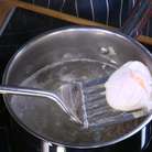 Приготовить яйца пашот: в небольшой кастрюле вскипятить воду, добавить уксус, с помощью венчика сделать маленький водоворот и в центр воронки вылить яйцо. Убавить огонь и варить 2–3 минуты, затем шумовкой выложить яйцо на бумажное полотенце. Так же приготовить второе яйцо.