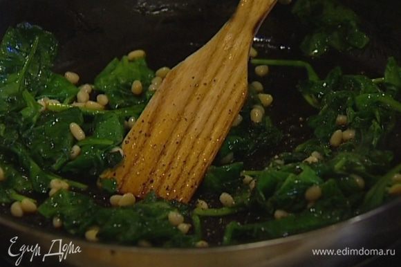 Разогреть в сковороде оливковое масло и потушить шпинат вместе с кедровыми орехами пару минут, затем поперчить, посолить и снять с огня.