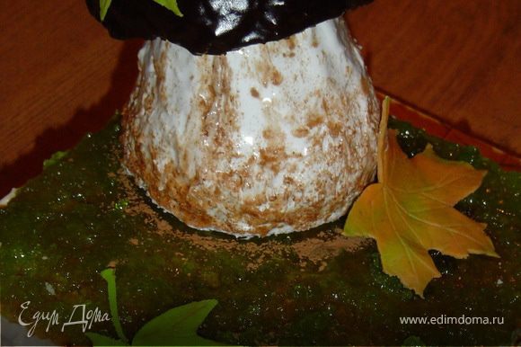 Варим глазурь (3 ложки какао, 3 ложки сахара, 3 ложки молока, 70 г масла) и покрываем ей шляпку гриба. Шляпку помещаем на ножку. Декорируем листьями из мастики.