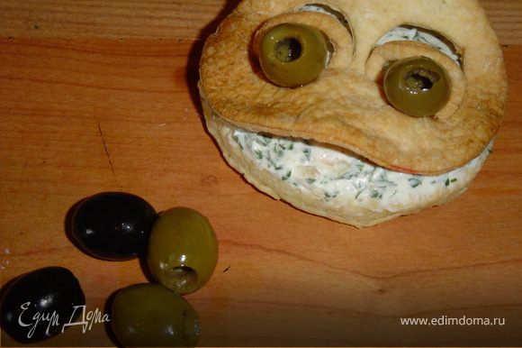 Сверху помещаем мордочку.Глазки делаем из оливок(без косточек),а зрачки - из маслин.Вставляем глазки в глазницы.