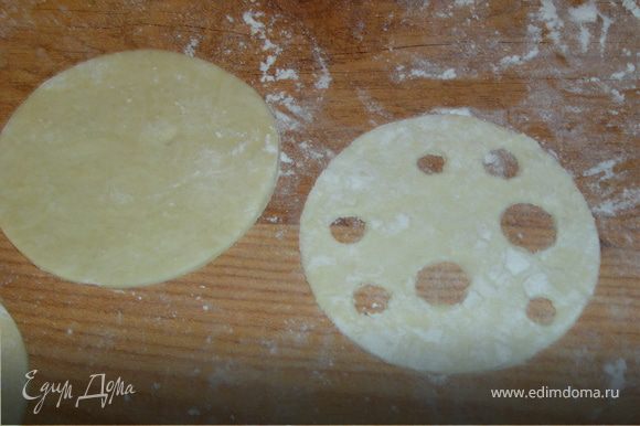 Раскатываем тесто и круглой формой вырезаем два одинаковых кружочка.В одном из них произвольно вырезаем несколько кружочков,иммитируя дырочки в сыре.Это кружочек будет являться в слоечке кусочком сыра.