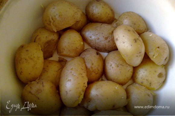 Картошку отварить в кожуре до полуготовности , дать ей остыть, разрезать вдоль пополам. В основании тажина налить 2 ст л оливкового масла и выложить картошку срезом вниз.