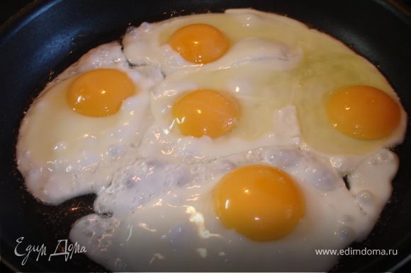 На разогретую с маслом сковору разбиваем яйца, от сковороды далеко не отходим