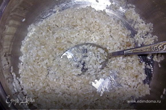 Нагреть оставшееся масло в кастрюле с толстым дном.Рис откинуть на сито,слить воду,положить в масло. Добавить сахар,соль и чёрный перец по вкусу.Тщательно перемешать.