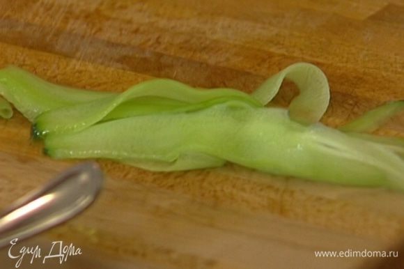 Огурец очистить от кожуры овощечисткой, затем ею же нарезать очень тонкие, почти прозрачные полоски.