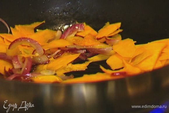Выложить тыквенные полоски в сковороду к луку с чесноком, добавить листья тимьяна и обжаривать 2–3 минуты.