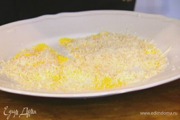 Кукурузную крупу насыпать в плоскую тарелку, добавить натертый сыр, перемешать.