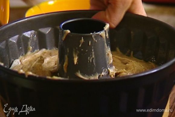 Смазать форму для кекса растительным маслом, выложить в нее тесто и разровнять ложкой.