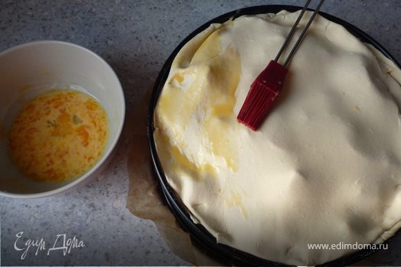 Оставшееся тесто раскатать и накрыть им пирог. Смешать желток и молоко, и обмазать пирог. Запекать в течение 1 часа.
