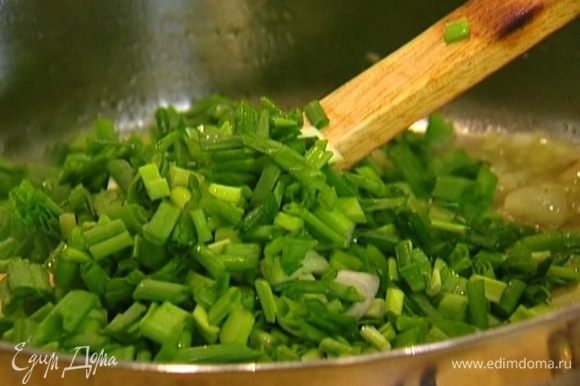 Добавить в сковороду листья тимьяна, зеленый лук и, непрерывно помешивая, подержать на огне еще 1–2 минуты.