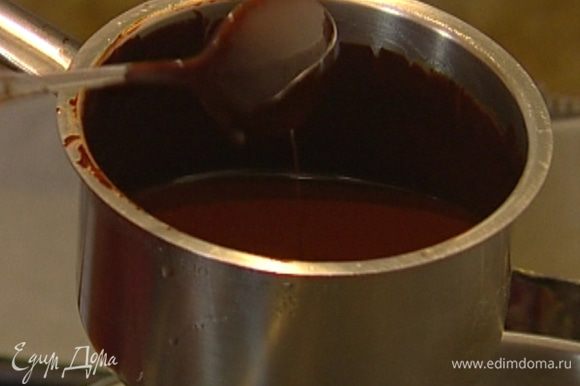 Черный шоколад поломать на кусочки, высыпать в небольшую кастрюлю, добавить сливочное масло и растопить все на водяной бане.