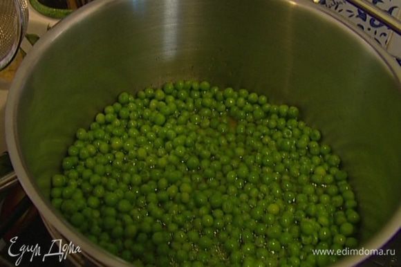 Зеленый горошек разморозить. Влить в кастрюлю немного воды и 1 ст. ложку оливкового масла, добавить горошек и отваривать его в течение 3 минут, затем воду слить.