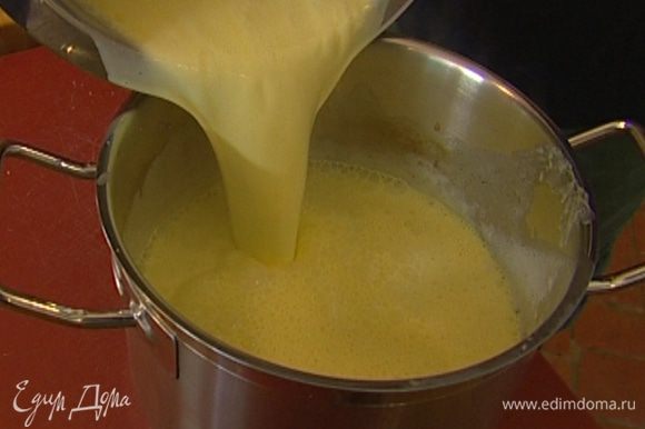 Непрерывно помешивая, тонкой струйкой влить в желтки горячие сливки с молоком.