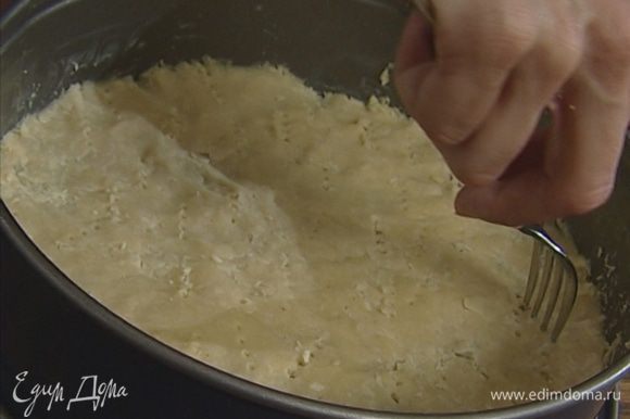 Смазать форму для выпечки сливочным маслом, выложить тесто, равномерно распределяя его. Проткнуть тесто в нескольких местах вилкой и поставить на полчаса в холодильник.
