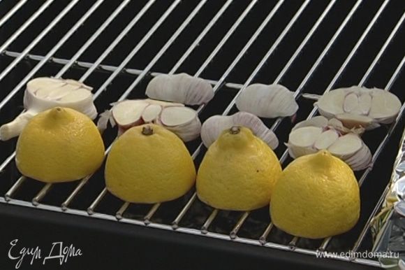 Положить лимоны разрезом на гриль, рядом — чеснок и черри на веточках, все обжарить.