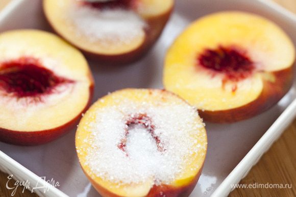 Посыпать персики сахаром, полить граппой и запекать в разогретой духовке 15–20 минут, затем остудить.
