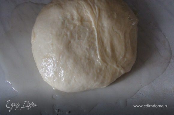 Когда тесто поднимется, на рабочую поверхность налить оливковое (подсолнечное) масло, выложить на него тесто. Разогреть сковороду с оливковым (подсолнечным) маслом.