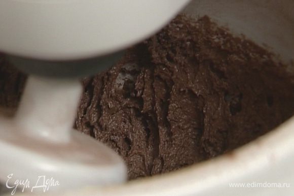 Яйца с сахаром взбить миксером, добавить муку с какао, ввести шоколадную массу и продолжать взбивать на небольшой скорости, пока тесто не станет однородным.