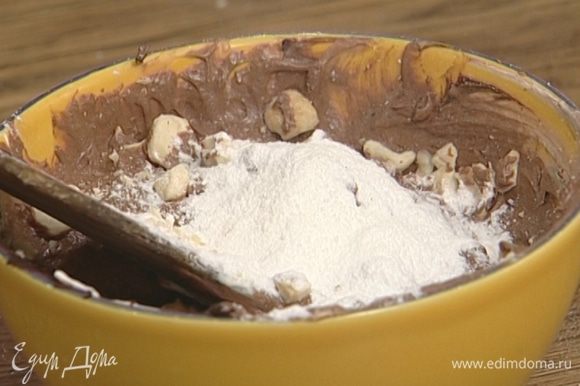 Добавить в шоколадно-сливочную массу орехи и 1 ч. ложку сахарной пудры, перемешать.
