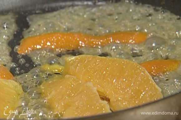 Растопить в сковороде 1 ч. ложку сливочного масла, добавить сахар, цедру, сок и кусочки апельсина и прогревать 2–3 минуты.