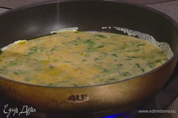 В сковороде с толстым дном разогреть оливковое масло, добавить взбитые яйца с сыром. Уменьшить огонь и дождаться, чтобы омлет схватился.