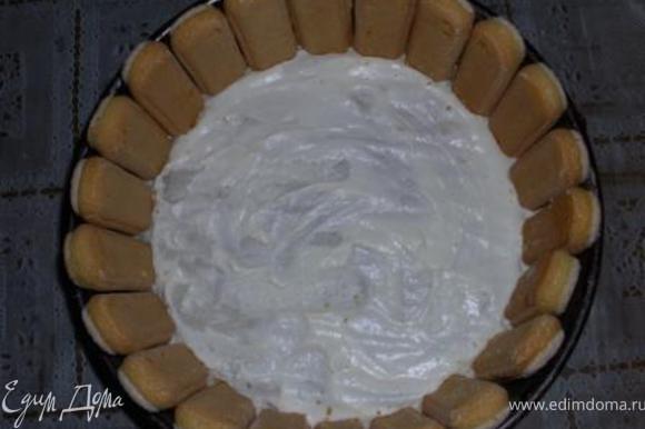 Разъемную форму выстелить пекарской бумагой и смазать немного кремом. Сделать бортик из печенья.