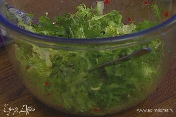 Листья салата выложить в глубокую посуду и полить заправкой.
