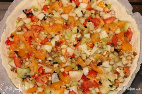 К смеси нарезанных овощей добавить оливковое масло, соль, перец, слегка перемешать, и выложить на тесто.