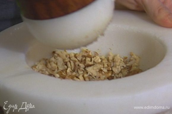 Грецкие орехи растереть в ступке с чесноком и щепоткой соли в однородную мелкую крошку.