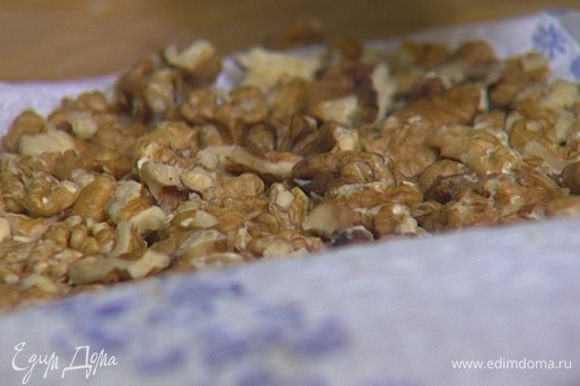 Грецкие орехи завернуть в кухонное полотенце и немного измельчить с помощью скалки.