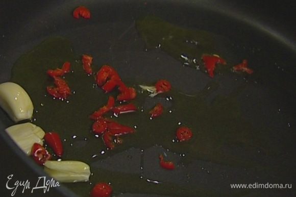 Разогреть в тяжелой сковороде оливковое масло и обжарить чеснок до золотистого цвета.