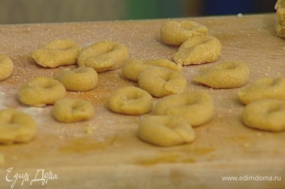 Вымешивать его руками в течение 5 минут, а затем сделать небольшие колбаски, соединив концы каждой так, чтобы получились небольшие пончики-бублики.