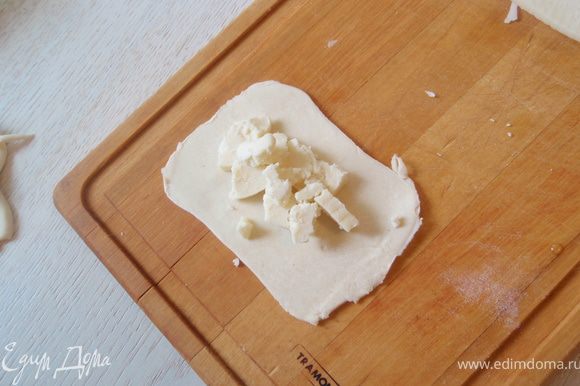 Квадратик раскатать ещё более тонко и выложить на него нарезанный сыр. Побольше, чтобы начинки было много!