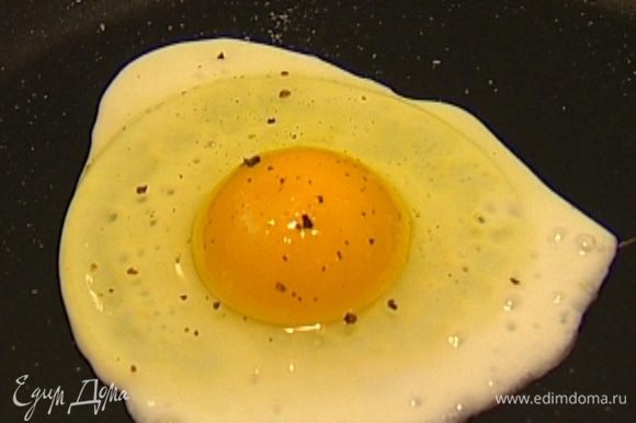 Яйца поджарить на сковороде, посолить и выложить сверху на галеты, украсить все шнитт-луком и подавать тут же.