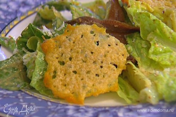 Разложить на листьях салата оставшиеся анчоусы и чипсы из пармезана.