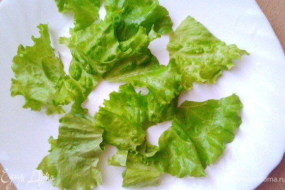 Листья салата помыть, высушить и порвать на дно салатницы.