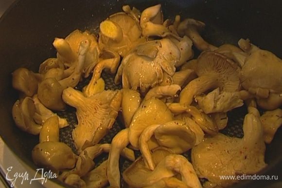 Разогреть в глубокой сковороде оливковое масло, выложить грибы, сразу же посолить, поперчить, добавить орегано, перемешать и обжарить, не накрывая крышкой.