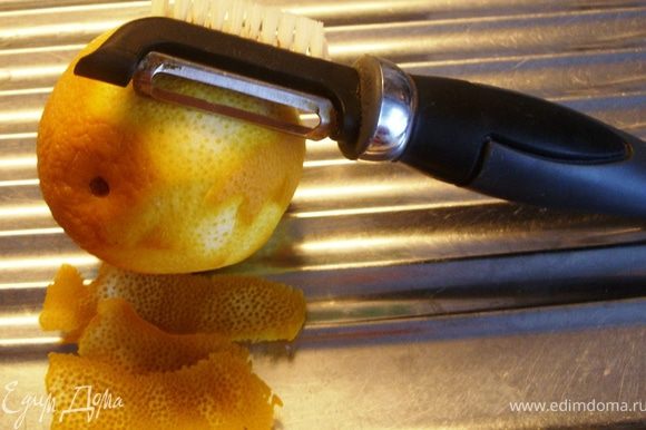 Овощечисткой аккуратно с апельсина снять цедру.