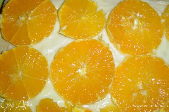 А на следующий корж - нарезанные на кружки апельсины.