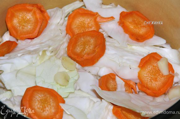 Капусту уложите плотно в кастрюлю, чередуя с морковью и чесноком.
