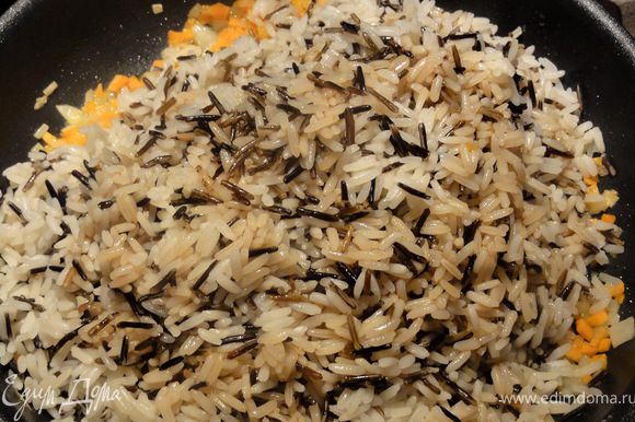 Добавить к овощам рис и перемешать, что бы овощи равномерно распределились. Влить соус и добавить обжаренный кунжут. Прогреть смесь помешивая, минут пять.