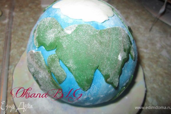 Из зеленой мастики вырезать "континенты", прикрепить на шар, смочив немного водой.