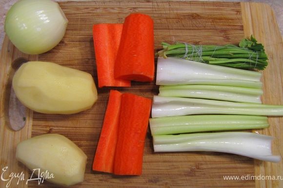 Приготовьте для начала овощной бульон. Для этого нарежьте крупно морковь и сельдерей (на 4 части). Почистите картофель. Почистите луковицу и воткните в нее гвоздику.