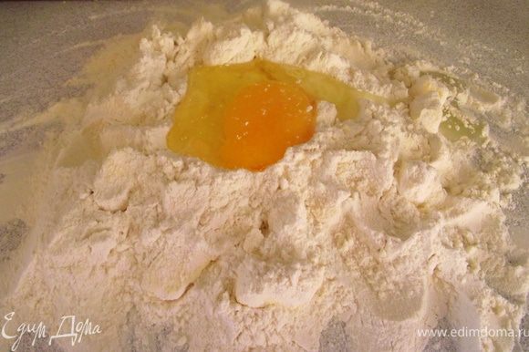 На рабочую поверхность просейте муку, добавьте сливочное масло и покрошите его ножом. Сделайте углубление, в него вбейте яйцо и добавьте две столовые ложки ледяной воды. Замесите тесто.