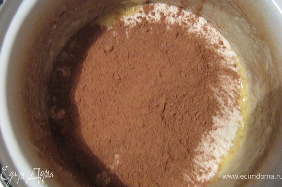 В масляную смесь просеиваем муку с какао и разрыхлителем.