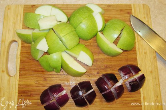 Почистите яблоки и лук. Разрежьте яблоки на 4 части. Удалите семена и перегородки. Разрежьте каждую четвертинку еще на 4 части (или пополам, если яблоки небольшие). Репчатый лук разрежьте на восемь частей.