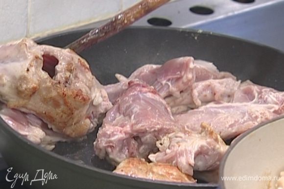 В глубокой сковороде, которую можно ставить в духовку, разогреть оливковое масло и обжаривать кусочки кролика до появления румяной корочки.