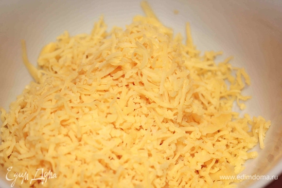 Делаем сливочную начинку. Сыр натереть на мелкой или средней тёрке. Добавить сливки и яйца. Перемешать.
