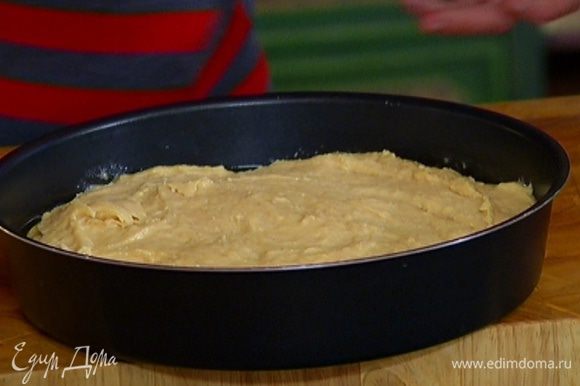 Выложить кольца ананаса в форму для выпечки, залить карамелью, сверху равномерно распределить тесто.